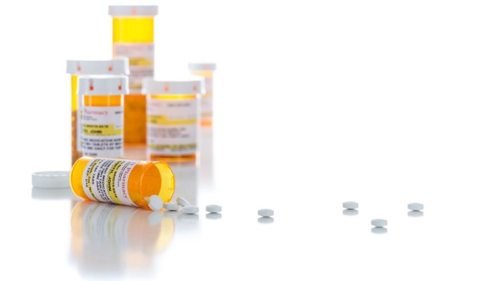 Non-Proprietary Medicine Prescription Bottles and Spilled Pills Isolated on a White Background.