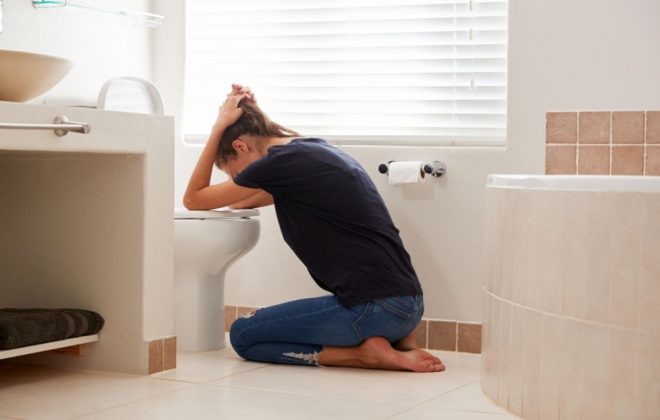 Woman Suffering With Morning Sickness In Bathroom At Home